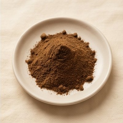 A plate with a mound of dark brown spice powder